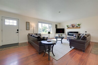 Living area with dark wood finished floors and a glass covered fireplace