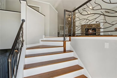 Staircase with a stone fireplace