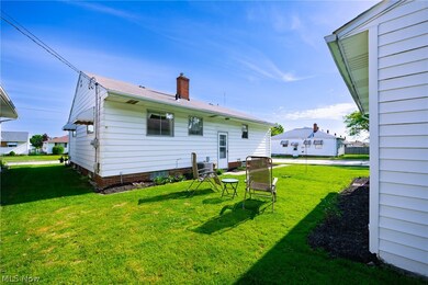 Rear view of property featuring a lawn and central AC unit