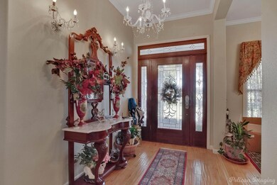 Entrance foyer with a notable chandelier, hardwood
