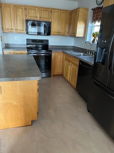 Kitchen with range, refrigerator, dark countertops, and dishwasher