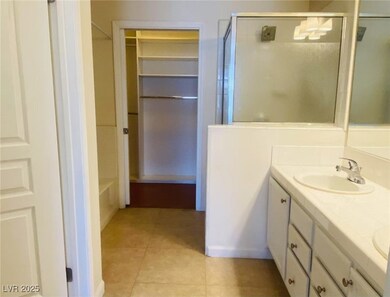 Bathroom with a stall shower, double vanity, tile