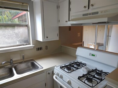 Kitchen with white range with gas stovetop, under