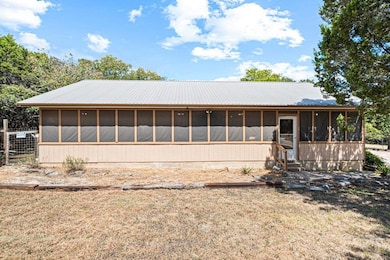 Rear view of house with a sunroom and a lawn