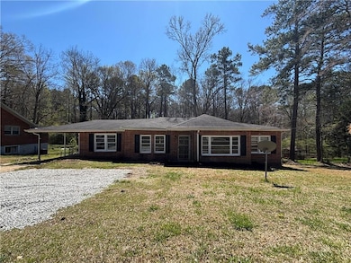 Single story home featuring brick siding, a carpor