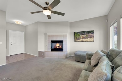 Living room with carpet flooring, a tiled fireplac
