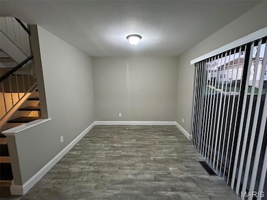 Spare room with stairway and dark wood-style floors