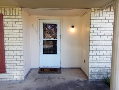 View of exterior entry featuring brick siding