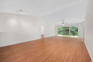 Unfurnished living room with ceiling fan, rail lig