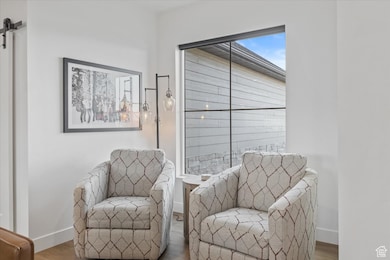 Living area featuring wood finished floors, baseboards, and a barn door