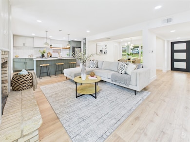 Living area with light wood-style flooring, reces