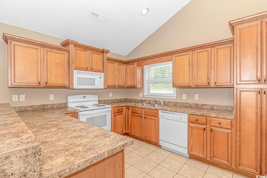 Kitchen featuring white appliances, light countertops, a sink, light tile patterned floors, and high vaulted ceiling
