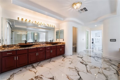 Bathroom featuring double vanity, toilet, a sink,