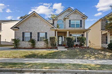 Traditional home with brick siding, covered porch, and a front lawn