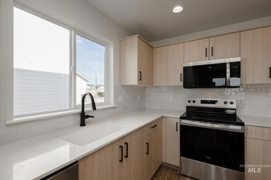 Kitchen featuring light brown cabinets, stainless steel appliances, decorative backsplash, light stone countertops, and recessed lighting