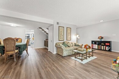 Living room with stairs, wood finished floors, and a textured ceiling
