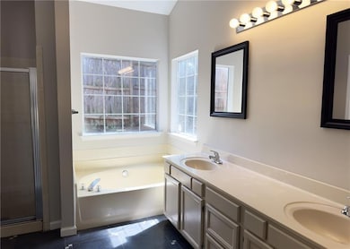 Unwind in this light-filled master bathroom featur