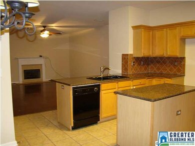 This kitchen has nice cabinets, tile flooring, isl