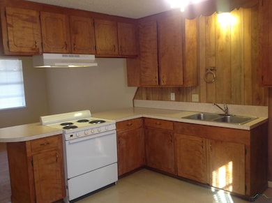 Kitchen featuring sink, white stove, and kitchen p