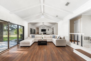 Living room with dark wood-style floors and crown molding