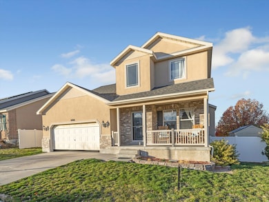 View of front of home featuring a porch, brick siding, driveway, stucco siding, and a garage