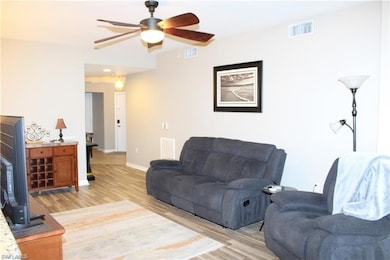 Living room with wood-type flooring and ceiling fan