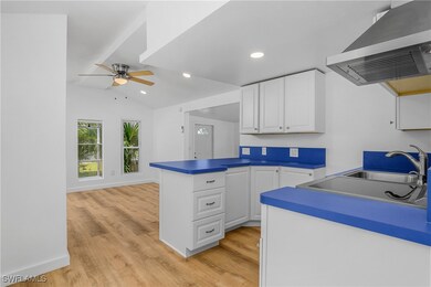 Kitchen with wall chimney exhaust hood, a ceiling