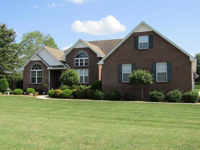Professionally landscaped yard with front sidewalk and concrete drive.
