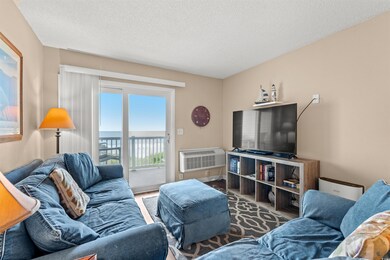 Living room with an AC wall unit, a water view, a 