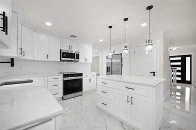Kitchen featuring stainless steel appliances, decorative backsplash, crown molding, recessed lighting, and pendant lighting