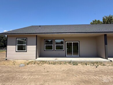 Back of house featuring a shingled roof and a patio