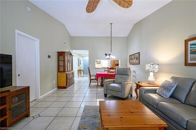 Tiled living room featuring ceiling fan with notab