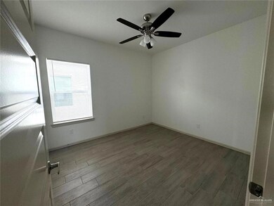 Spare room with a ceiling fan, wood finished floors, and baseboards