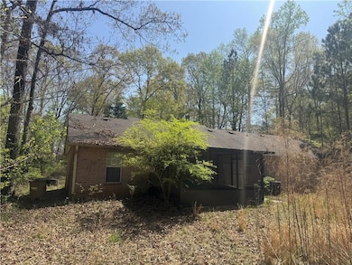 View of home's exterior with brick siding and a shingled roof