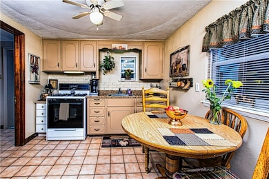 Eat in Kitchen with tile flooring and ceiling fan.