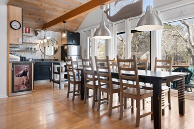 Bright open floor plan - dining table seats 10 with sliding glass doors leading to a wrap-around deck with lounge area and grill.