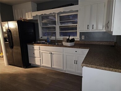 Kitchen with dark wood-type flooring, white cabine