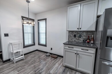 Kitchen featuring stainless steel fridge, dark har