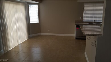 Empty room featuring a sink, baseboards, and tile