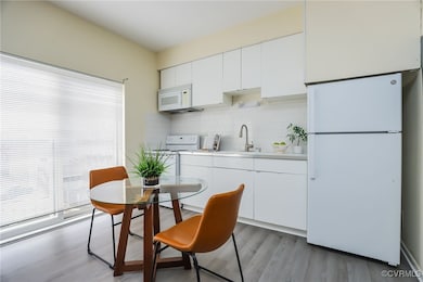 Kitchen with sink, white cabinets, white appliance