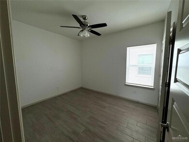 Empty room with a ceiling fan, wood finished floors, and baseboards