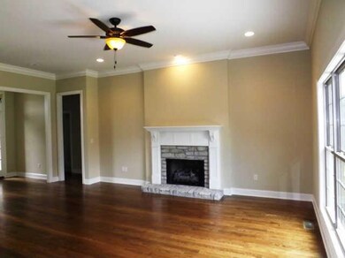 The living room features a gas fireplace, triple windows overlooking the back lawn and site-finished hardwood floors. 