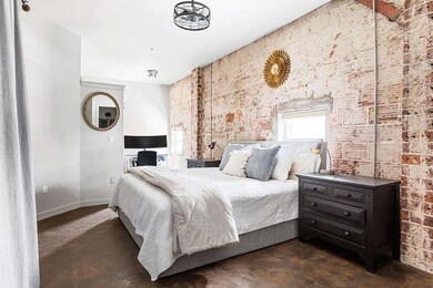 Bedroom with brick wall and baseboards