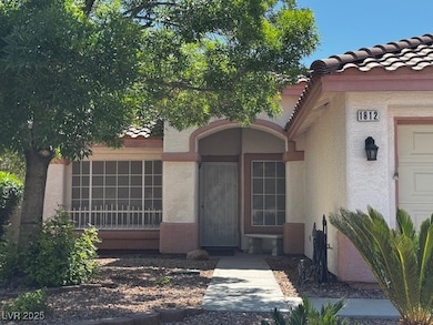 View of exterior entry featuring a tile roof and s