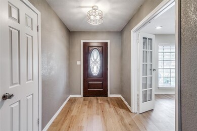 Foyer with light wood-type flooring, a notable cha