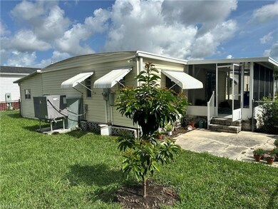 Rear view of house featuring a yard and a sunroom