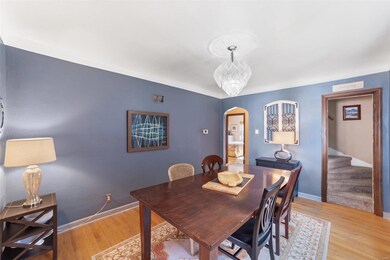 Spacious dining room with hardwood flooring, coffered ceiling and access to kitchen and upper level.