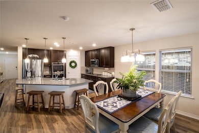Dining area featuring dark wood-style flooring, recessed lighting, and a chandelier