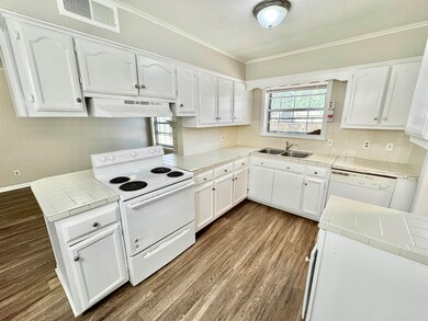 Kitchen featuring sink, tile countertops, white ap