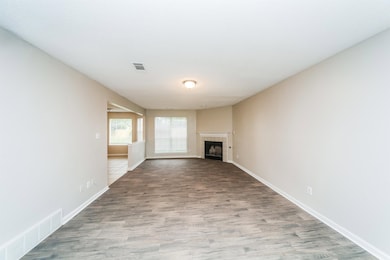 Unfurnished living room featuring wood finished floors and a fireplace